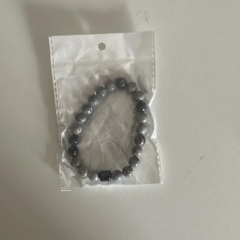 Två armband med pärlor, ett i grått och ett i vitt med grå marmorering. Båda armbanden har elastiska band för enkel passform. Ett armband för 49 två för 59. Pris går att diskutera . Asusteet.