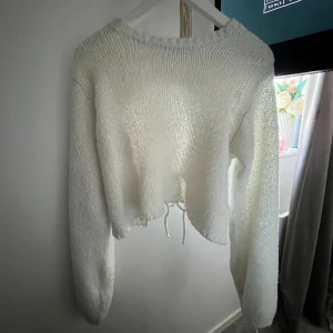 Stickad tröja med öppen rygg (nakd) - Säljer min tröja från nakd, helt slutsåld. har dock en liten defekt på armen att några trådar gått upp men går inte upp mera eller så. Nypris 500kr 