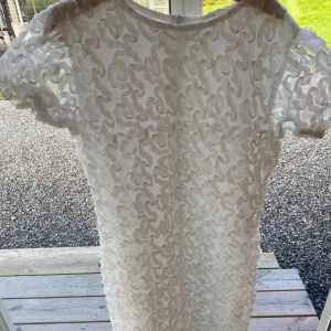 Vit klänning - Klänningen har storlek 152 och den är ganska genomskinlig. Den har aldrig använts.