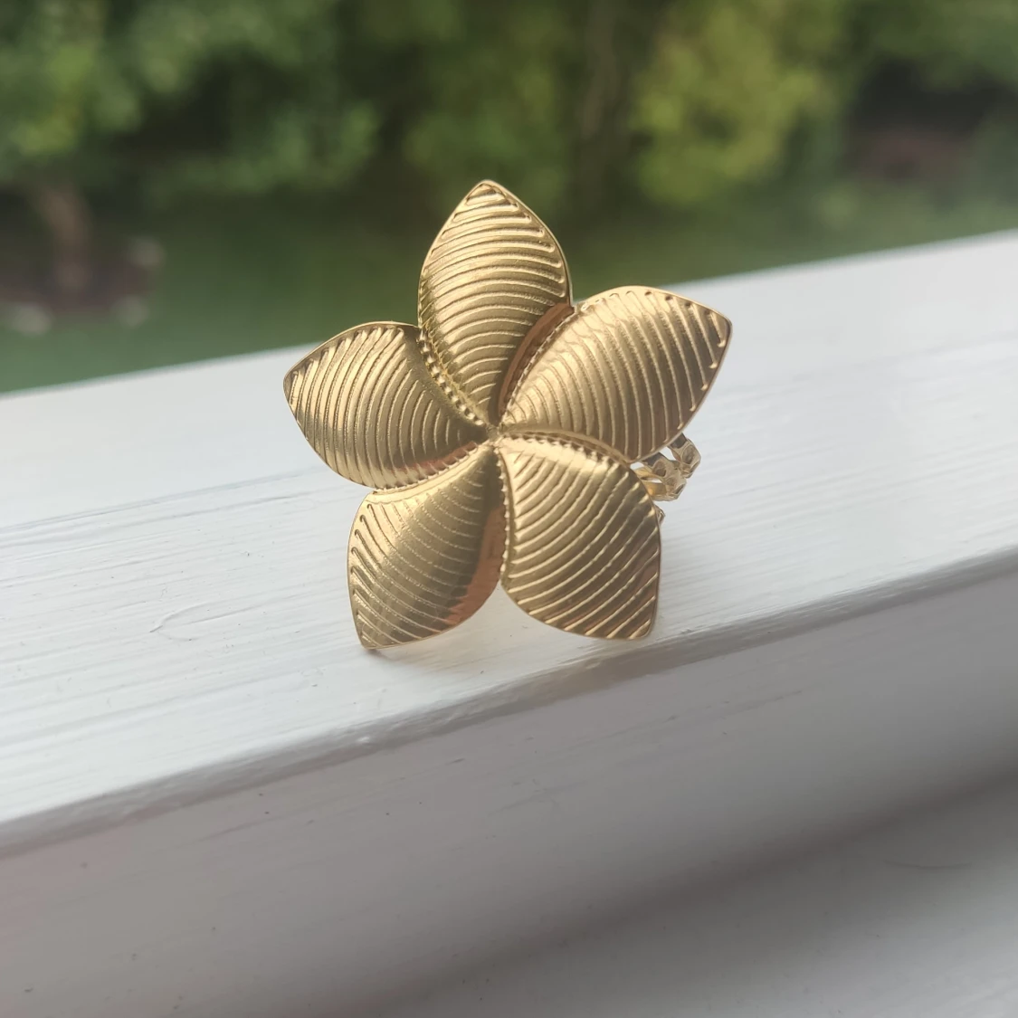 Guldfärgad ring med blomdesign