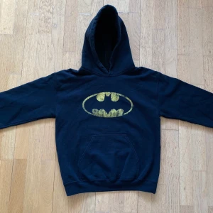 Hoodie med Batman-tryck - Skön hoodie med Batman logga/tryck på. Lite sliten logga, men utöver det är tröjan i gott skick!