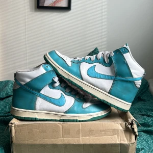 Nike dunk high ”mineral blue” - Nike dunk high ”mineral blue” ostrich pack 2011 väldigt fina skor i storlek 44 det är väldigt bra skick för en 12 år gammal sko, dem billigaste jag kan hitta online ligger på cirka 2500-3000 men dem här har använts. Swooschet är gjort av strutsskinn