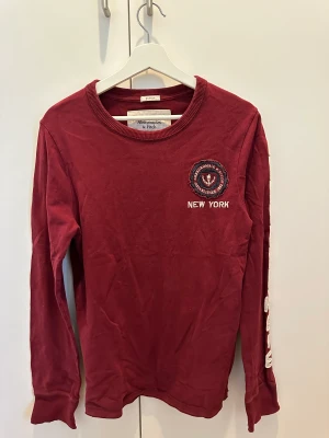 Långärmad tröja vinröd - Lite distress look på tröjan som e meningen