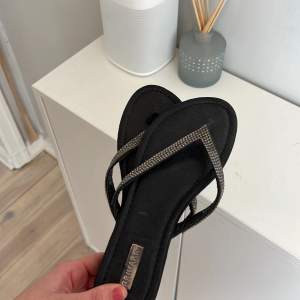 Svarta snygga flipflops skor med glitter detalj! Köpta förra året på Primark i London. Storlek 38!