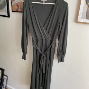 Klänning från hm - En vadlång grön klänning från hm. Inga fel vad jag kunnat se, använd ett fåtal gånger. Trikåtyg. Följsam och feminin.