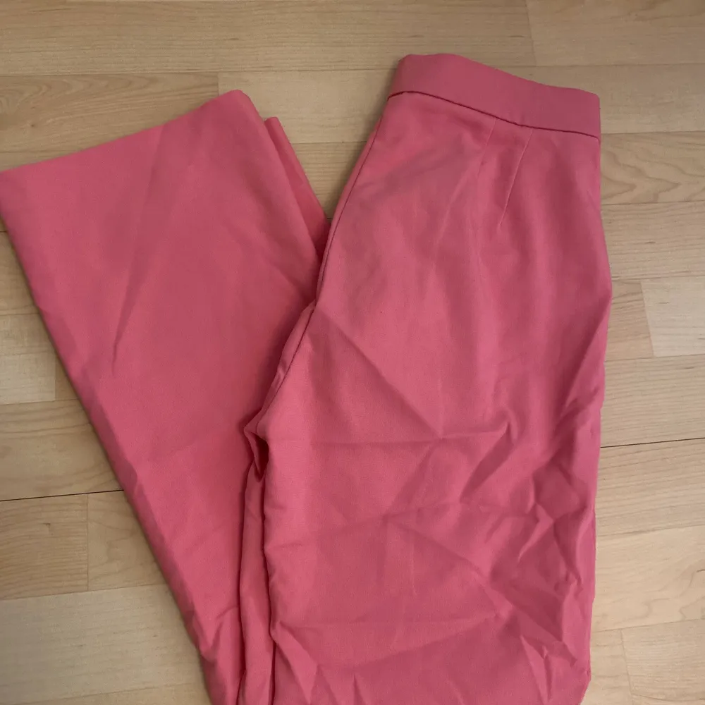 Ett par av mina favoritbyxor som blivit försmå. Rosa kostymbyxor med fickor vid fram. Utsvängda längst ner. Passar inte till längre människor. Farkut & Housut.