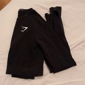 Gymshark topp - Svart Gymshark cropped träningströja från vital serien, använd fåtal gånger.  Passar bra med dem gröna tightsen jag säljer.  Strl. Xs/S    Ord.pris: 449kr 