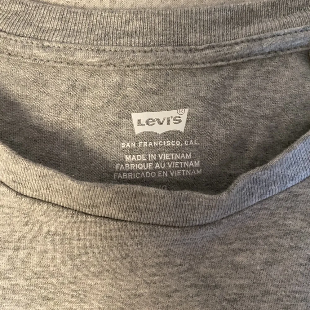 En fin grå Levis t-shirt med blått tryck, andvänd ca 2 ggr i strl M/L . T-shirts.