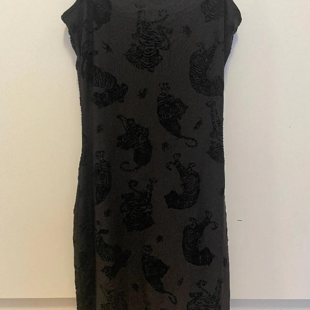 jag säljer denna gulliga svarta klänning med tigrar på, aldrig använd⭐️köpt för nåt år sedan på hm💞 kontakta för frågor eller flera bilder🫶🏼. Klänningar.