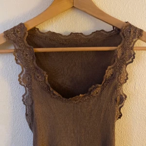 Spets topp - Brunt linne med spetskant. Köptes på Åhléns för några år sedan men knappt använt. ONESIZE, passar allt från XS-L då det är ett så stretchigt material! ❤️