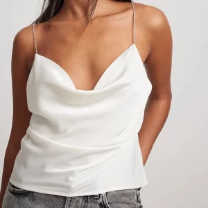 Satin topp - Så fin satin topp från nakd med strass axelband och ”waterfall-neck” Färgen är cremevit🤍