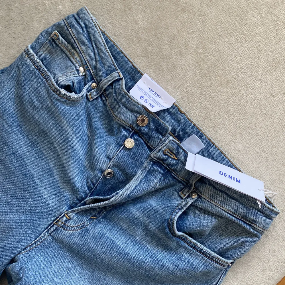 NWT. Ljusblåa jeans från H&M. Mom jeans, high waist & loose fit. . Jeans & Byxor.