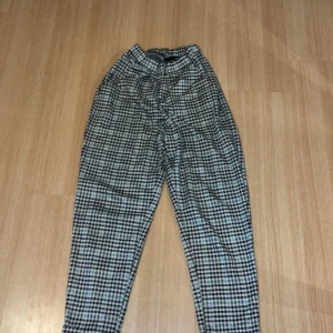 Rutiga kostymbyxor - Väldigt mjukt tyg så kan även användas som mjukisbyxor. Inga tecken på användning och stretchig midja. Den är svart, vit och lite grön