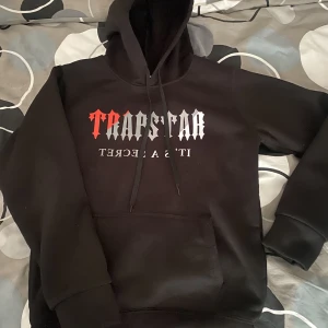 Jag säljer en Svart Trapstar Hoodie (inga mjukis med, bara hoodien) - Det funkar för både tjej och kille som är runt 12-15 år.Men om du är kort och smal så kanske det också funkar.Skön bomull inne,skön material och använd 1-2 gånger.
