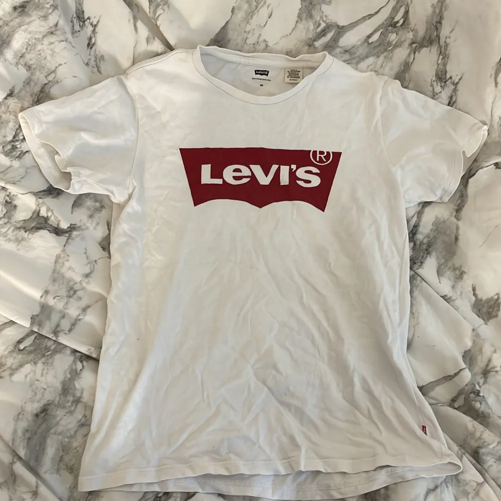 Vit Levi’s T-Shirt med rött tryck (några små fläckar som knappt syns). T-shirts.