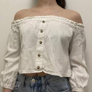 A white long sleeved top (off shoulder). Sleeves don’t go fully to the wrist, just a bit above the wrist. Really good for spring and summer. I’m good condition (no rips)