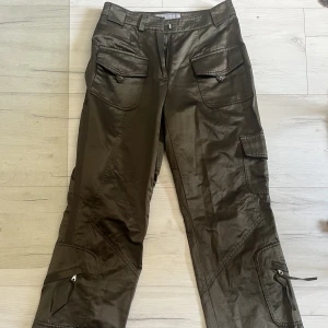Militärgröna byxor - Storlek 34, glansigt material, sitter jättefint men de är lite för små för mig i midjan. Lite långa på mig som är 151.