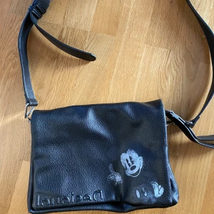 Designat Väska !! - svart, oanvänd och snygg väska som jag gärna vill sälja snabbt! Mycket förvaring och i bra skick 😋 Inuti är det mönster av musse pigg i grönt :))