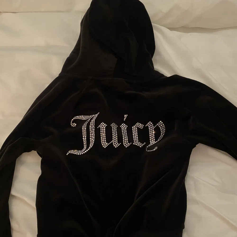 Juicy Couture hela settet i svart, byxor, zip hoodie och bandeau top! Knappt använt så inga defekter, väldigt bra skick! Skriv för fler bilder🤍. Jeans & Byxor.