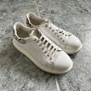 Vita sneakers - Vita sneakers med orm skinns detalj baktill, använda men fortfarande i fint skick🐍🤍🤍 köpta på nelly för längesen