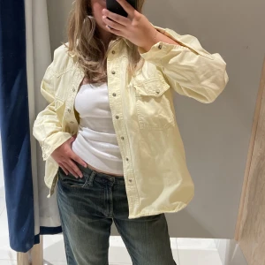 Gul oversize denimskjorta - Säljer denna underbara ljus-gula jeansjackan då den inte kommer till användning.💛Skjortan är i en oversize fit på mig som brukar bära S/M & är 165cm lång. Om du har övriga frågor eller vill ha fler bilder är det bara att hmu! 