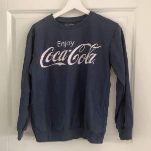 Marinblå CocaCola T-shirt i storlek S.