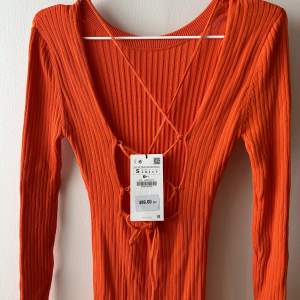 ribbstickad klänning med öppen rygg från Zara. Helt oanvänd. Stark orange färg. Väldigt stretchig så den passar S-M