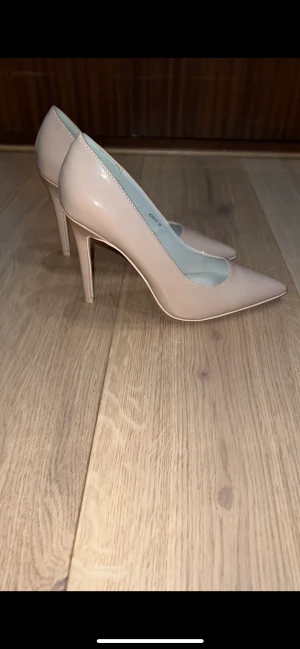 Stilettklackar 38 - Beiga klackar från Nelly, aldrig använda. Storlek 38.  Köparen står för frakten. 