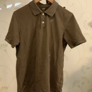 Brun Uniqlo piké - Snygg piké av Uniqlo, storlek L. Endast använd ett fåtal gånger, så tröjan är i väldigt bra skick.