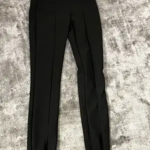 Ett par svarta kostym tights med sömmar och slit 