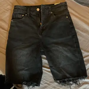 Urtvättade jeansshorts i en längre modell med slitningar nedtill 