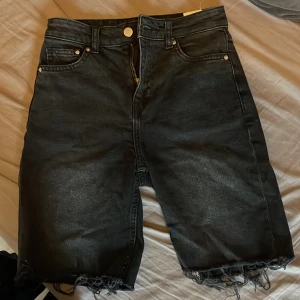 Jeansshorts - Urtvättade jeansshorts i en längre modell med slitningar nedtill 