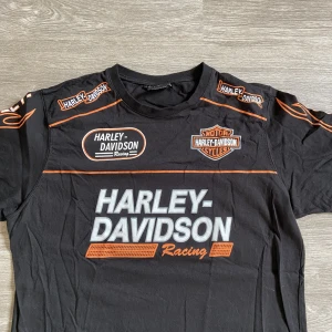 Harley Davidsson tshirt  - En Harley Davidsson tshirt. Färg svart med print. Storlek L enligt tagg. Mått: •längd 72cm. •armhåla till armhåla ca 51cm.
