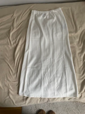 Lång vit kjol - Jätte fin lång kjol i silk material. Perfekt till sommaren. Säljer då den inte passar mig längre💕
