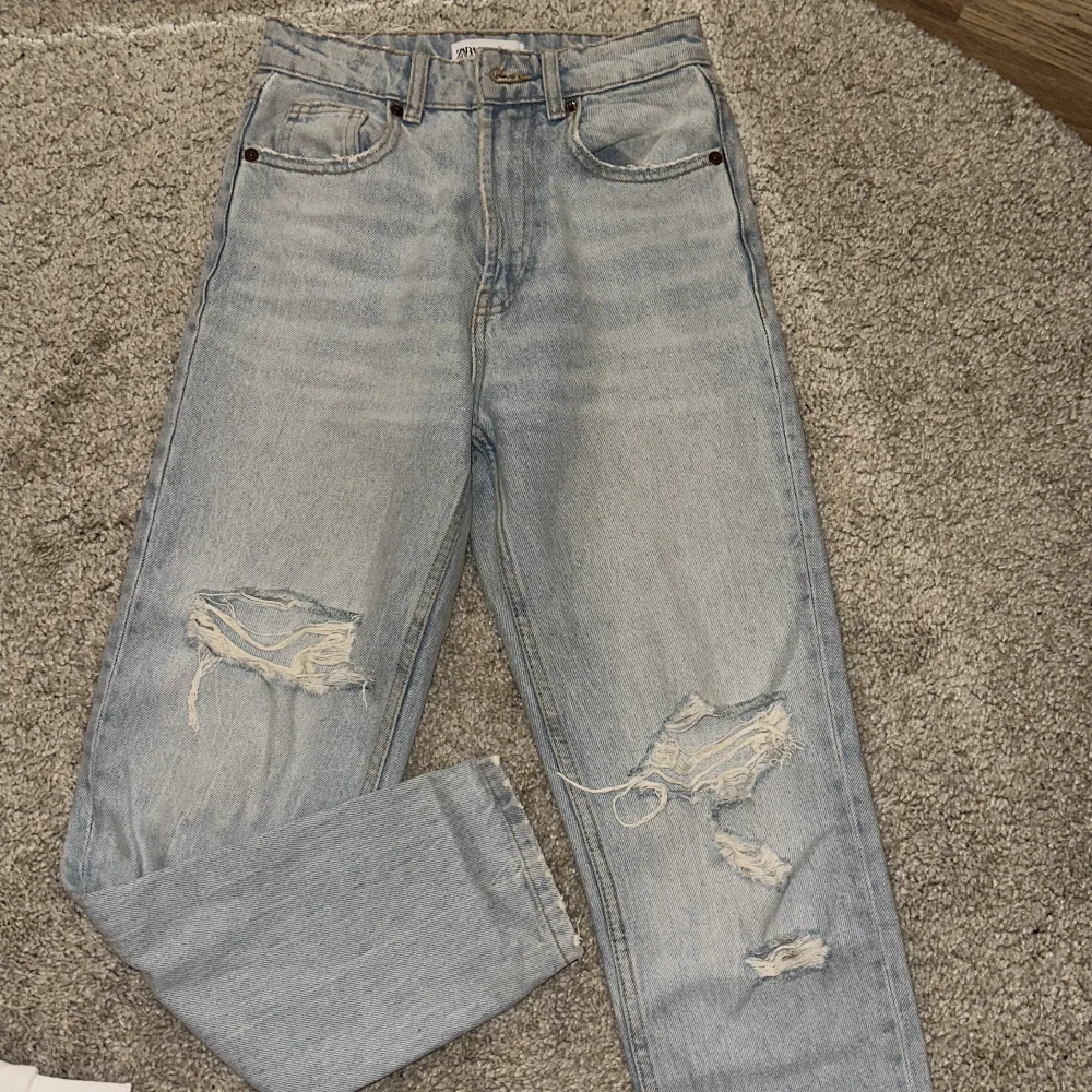 Slitna mom jeans från zara som endast är använda en gång, bilden är lite orättvis men färgen är en ljus tvätt . Jeans & Byxor.