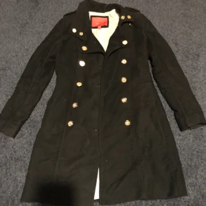 Svart sjömans kappa - Svart kappa med guld knappar från Mango. Knappt använd, häng öglan är sönder, annars hel och fin!