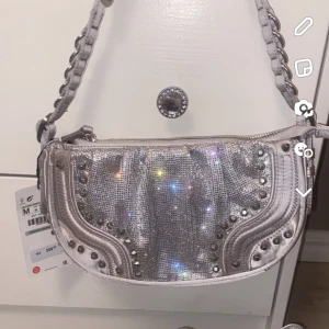 ZARA väska - Glittrig väska från ZARA med nitar. Köpt för 560kr, använd vid ett tillfälle. Ser ut som ny!