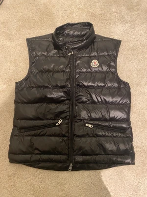 Moncler gui väst  - Tjena, säljer min Moncler gui väst som jag köpt på plick den är för stor för mig då säljer den igen. Den är i bra Skick 9/10 inget kvitto. Skriv vid minsta fundering  storlek 1/S 