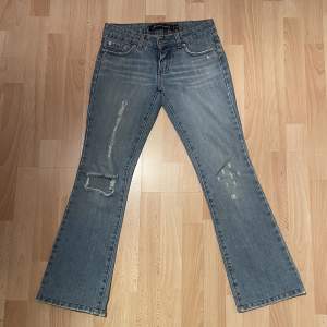 Vintage jeans med lågmidja och utsvängda ben. En slitning på baksidan strax under rumpan (se bild) Midjemått: ca 35cm tvärsöver Innerbenslängd: ca 74cm