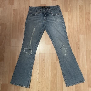 Lågmidjade Jeans - Vintage jeans med lågmidja och utsvängda ben. En slitning på baksidan strax under rumpan (se bild) Midjemått: ca 35cm tvärsöver Innerbenslängd: ca 74cm