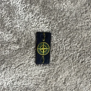 Stone island logga/ märke - Stone island logga/ märke säljes. Bra skick . Säljes för att min stone island tröja är för sliten för att sälja därför säljer jag bara loggan.