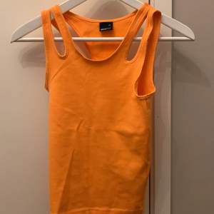 Ett orange linne som sitter lite tajt Aldrig använd