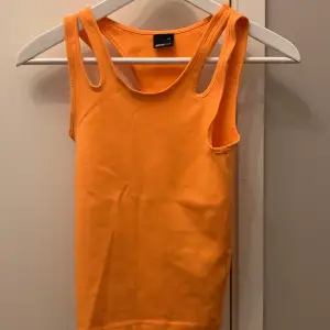 Ett orange linne som sitter lite tajt Aldrig använd