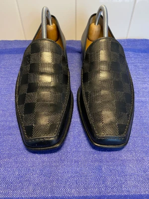 Retro svarta Louis Vuitton loafers storlek 41-41,5 - Svart elegant herrsko från Louis Vuitton i storlek 41-41,5. Retro. Skon är i ett väldigt bra skick, den är använd 3-gånger i rätt korta stunder då det inte var rätt storlek för mig. 