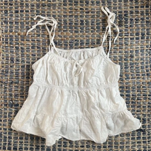 Vit mini topp - Säljer denna vita minitopp då den inte kommer till användning längre, den är tunn i materialet och har en knytning vid bysten. De är bara att skriva för fler bilder/frågor🩷🫶