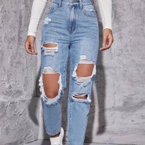 Blåa jeans - Blåa jeans med hål. Storlek XS, sitter fint på mig som är 160 cm. Använda få gånger och är i ett bra skick.