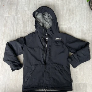 Burton jacka - Svart Burton vinterjacka i fint skick förutom en rispa på vänster arm och ett litet på ryggen. Använd 1 säsong av ett barn. Storlek 152/158. Pris 500kr.   