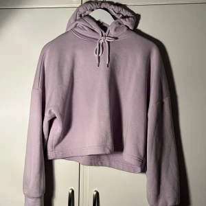 Lila hoodie  - Lila croppad hoodie från NA-KD. Säljer pga att den inte kommer till användning 