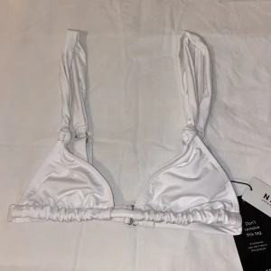 NA-KD trinagelbikinitopp - En vit clean trinagelbikinitopp från NA-KD. Storlek S. Orginalpris: 229kr. Säljer då den inte passar.