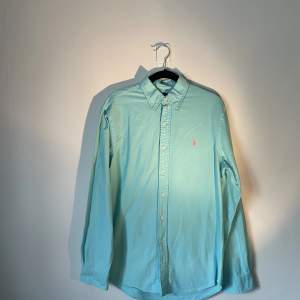 Turkos Ralph Lauren skjorta i turkos färg med råsa märke. Använd men i gott skick. Storlek M